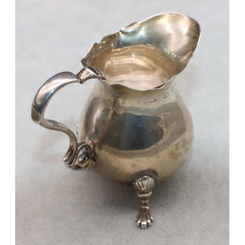 423 - A small Victorian silver cream jug with crinkle rim and scroll handle on splayed feet, 6.5cm high, 1... 