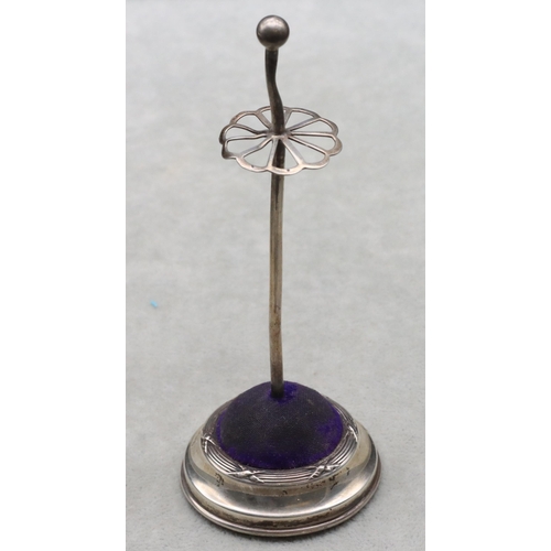 438 - A George V silver standing hat pin on round sweeping base, 14cm high