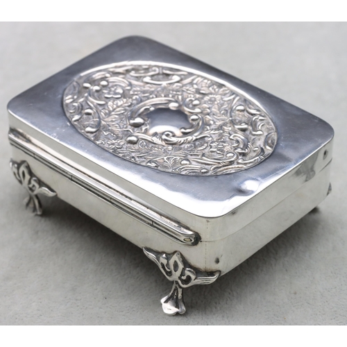 440 - An Edward VII silver rectangular trinket box with hinged lid, embossed floral and scroll decoration,... 