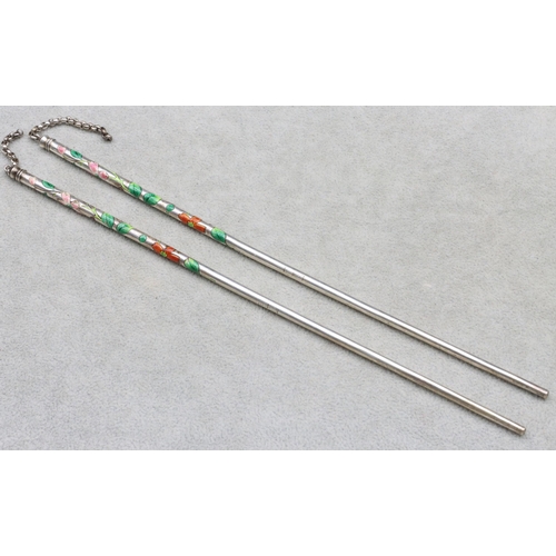 449 - A pair of Oriental silver coloured metal chopsticks with multi-coloured enamelled floral and leaf de... 