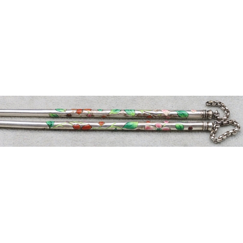 449 - A pair of Oriental silver coloured metal chopsticks with multi-coloured enamelled floral and leaf de... 