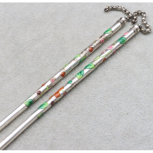 449 - A pair of Oriental silver coloured metal chopsticks with multi-coloured enamelled floral and leaf de... 