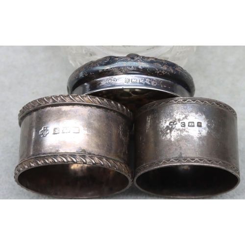 452 - A Birmingham silver round napkin ring, a heavy London silver round napkin ring and a cut glass dress... 