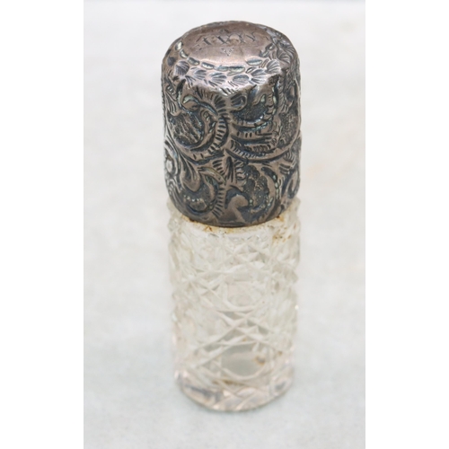 482 - A Victorian cut glass cylindrical scent bottle with embossed leaf and scroll decorated siler screw l... 