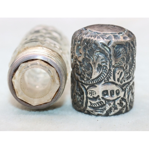 482 - A Victorian cut glass cylindrical scent bottle with embossed leaf and scroll decorated siler screw l... 