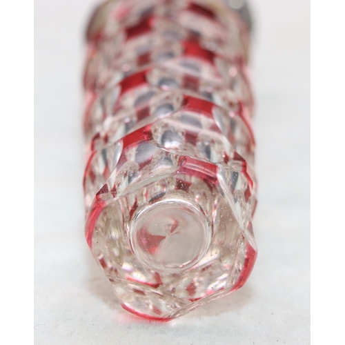 483 - A ruby and clear glass scent bottle with allover thumb decoration with embossed floral and scroll de... 