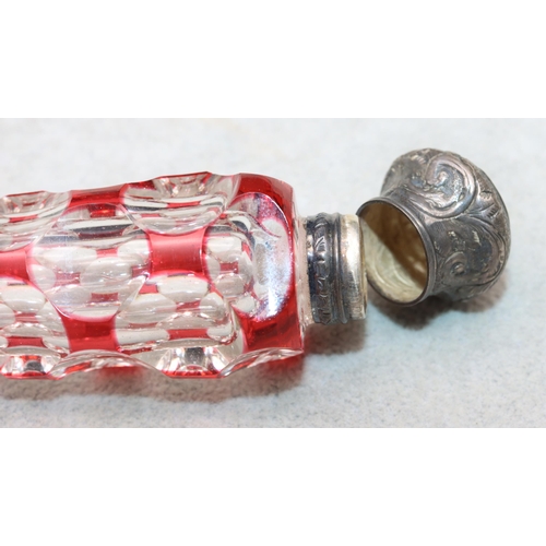 483 - A ruby and clear glass scent bottle with allover thumb decoration with embossed floral and scroll de... 