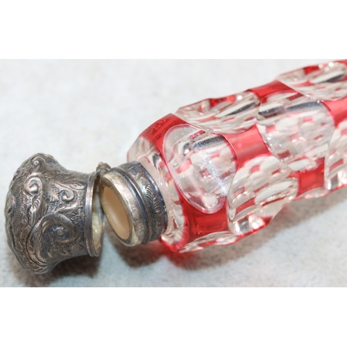 483 - A ruby and clear glass scent bottle with allover thumb decoration with embossed floral and scroll de... 