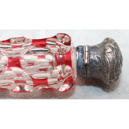 483 - A ruby and clear glass scent bottle with allover thumb decoration with embossed floral and scroll de... 