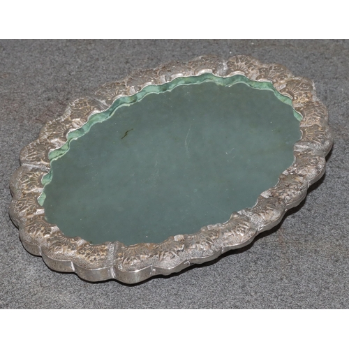 491 - An Eastern silver coloured metal oval scallop shaped hand mirror with raised and embossed bird, flor... 