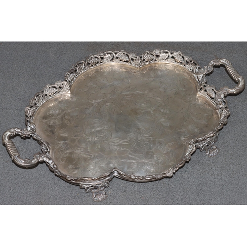 495 - A Continental silver coloured metal 2-handled scallop shaped tray with embossed and pierced floral g... 