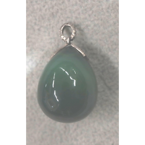 708 - A jade egg shaped pendant with silver clasp inset with small diamonds, 3.2cm high overall