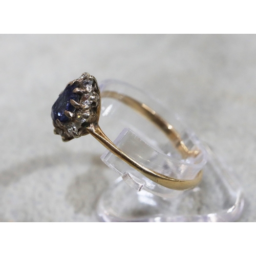 714 - A ladies' gold oval cluster ring set with centre pale blue stone surrounded by small diamonds (blue ... 