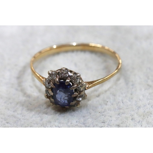 714 - A ladies' gold oval cluster ring set with centre pale blue stone surrounded by small diamonds (blue ... 