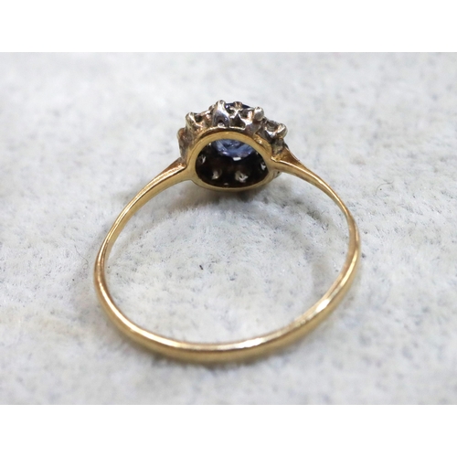 714 - A ladies' gold oval cluster ring set with centre pale blue stone surrounded by small diamonds (blue ... 