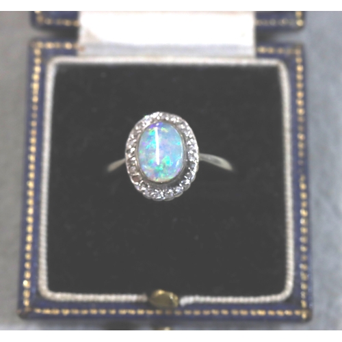 715 - An 18ct white gold ladies' oval cluster ring set with centre black opals surrounded by small diamond... 