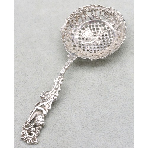 299 - A Continental silver coloured metal sifter spoon with cupid handle having raised pierced figure, flo... 