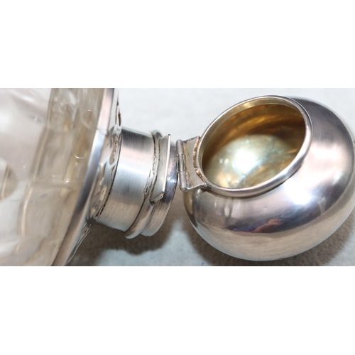 463 - A cut glass round bulbous shaped scent bottle with London silver neck and hinged lid (hinge a/f), en... 