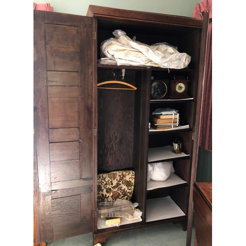 2348 - An oak double cupboard with 2 panel doors, brass lock and key (later sides), enclosing interior uppe... 