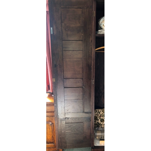 2348 - An oak double cupboard with 2 panel doors, brass lock and key (later sides), enclosing interior uppe... 