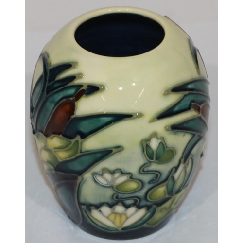 100 - A modern Moorcroft round bulbous shaped small vase on yellow and blue ground with multi-coloured lil... 