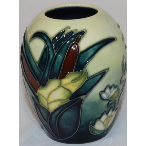 100 - A modern Moorcroft round bulbous shaped small vase on yellow and blue ground with multi-coloured lil... 