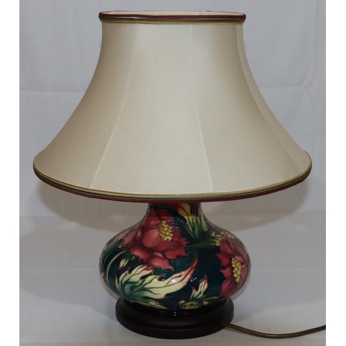 104 - A modern Moorcroft round bulbous thin necked table lamp on green ground with multi-coloured floral a... 