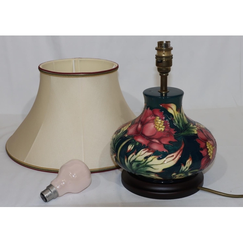 104 - A modern Moorcroft round bulbous thin necked table lamp on green ground with multi-coloured floral a... 