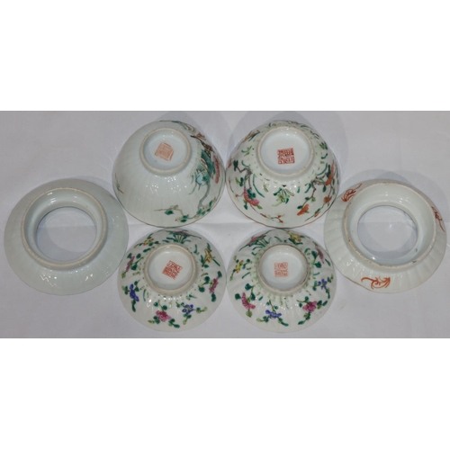 107 - A pair of Oriental round bulbous lidded bowls with saucers on white ground with multi-coloured flora... 