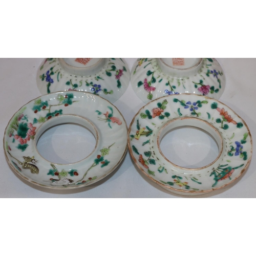 107 - A pair of Oriental round bulbous lidded bowls with saucers on white ground with multi-coloured flora... 