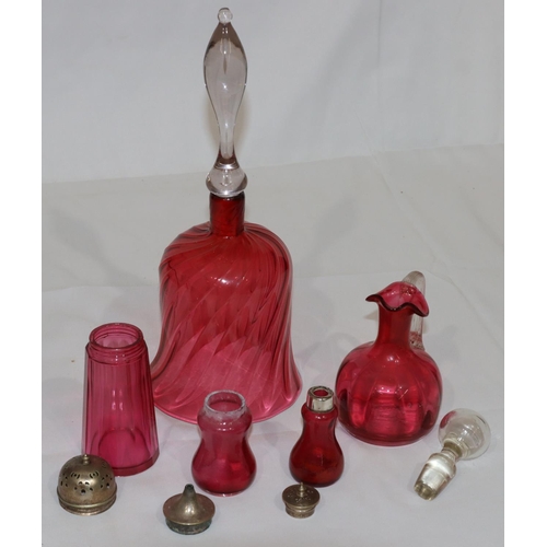 111 - A ruby and clear glass large hand bell, 32cm high (no clapper) and 4 further cranberry glass pepper ... 