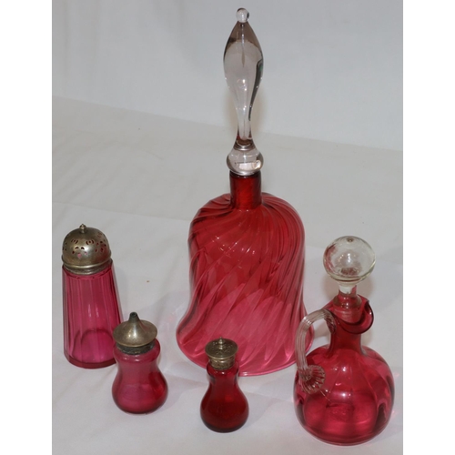 111 - A ruby and clear glass large hand bell, 32cm high (no clapper) and 4 further cranberry glass pepper ... 