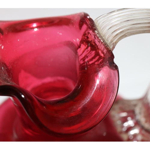 111 - A ruby and clear glass large hand bell, 32cm high (no clapper) and 4 further cranberry glass pepper ... 