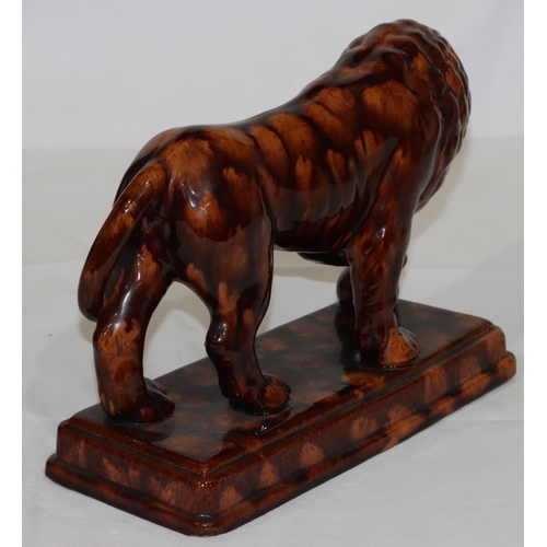 114 - A Treacle Ware style model of a lion on rectangular shaped base, 31cm long, 22cm high