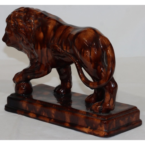 114 - A Treacle Ware style model of a lion on rectangular shaped base, 31cm long, 22cm high