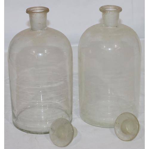 126 - A pair of plain glass round bulbous thin necked chemist's jars with stopper, 30.5cm high