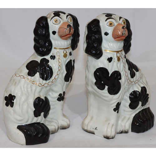 133 - A pair of 19th Century Staffordshire figures of seated spaniels on white and black ground with gilt ... 