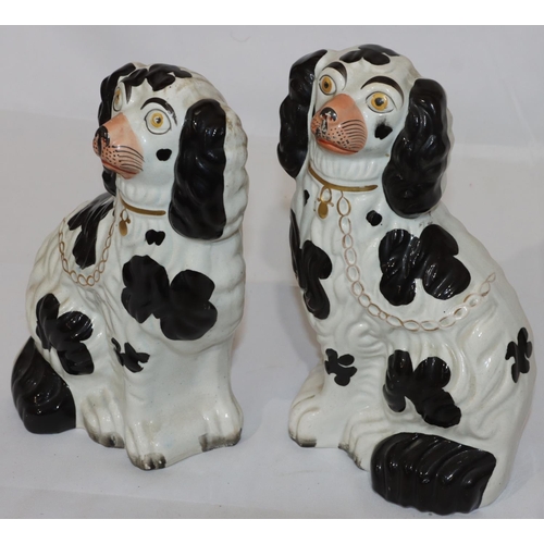 133 - A pair of 19th Century Staffordshire figures of seated spaniels on white and black ground with gilt ... 