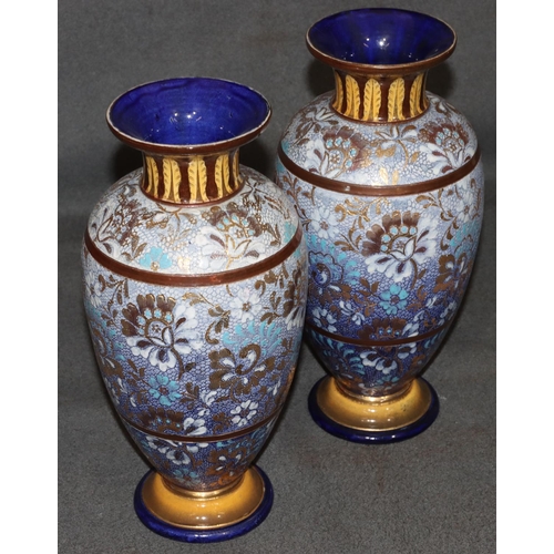 20 - A pair of Royal Doulton glazed earthenware round bulbous thin necked trumpet shaped vases on blue an... 