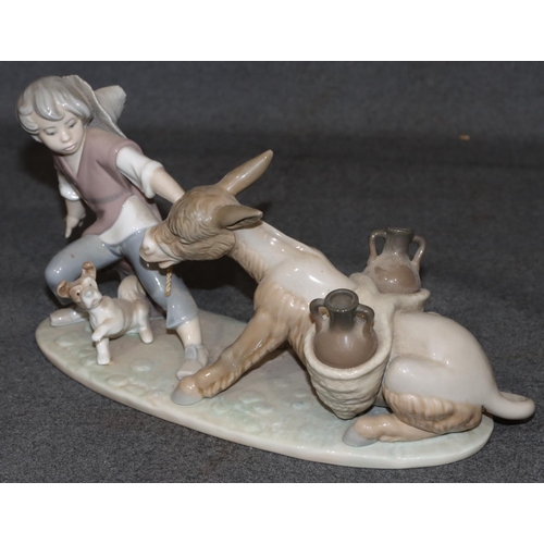 28 - A Lladro group of figure and dog pulling donkey (boy's right arm restored), 28cm long, 14cm high