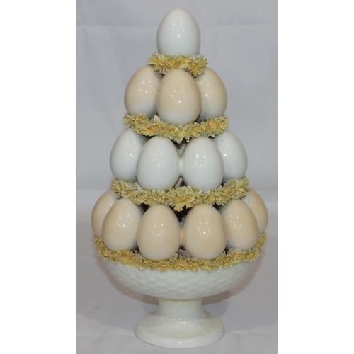 59 - A Majolica and encrusted china ornament in the form of a stack of eggs, 35cm high