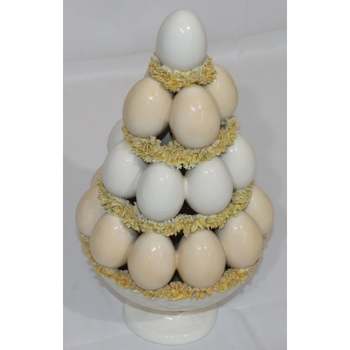 59 - A Majolica and encrusted china ornament in the form of a stack of eggs, 35cm high