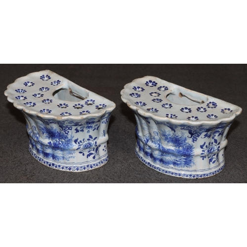 67 - A pair of Dutch blue and white bough pots with figure, floral and landscape decoration, 17cm wide