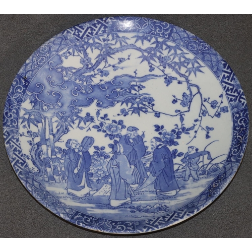 7 - A Japanese round blue and white charger with figure, bamboo and tree decoration, 31cm diameter