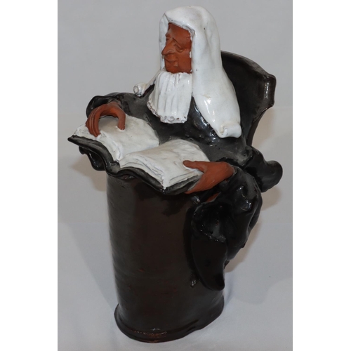 76 - A glazed earthenware figure of a seated judge, 31cm high