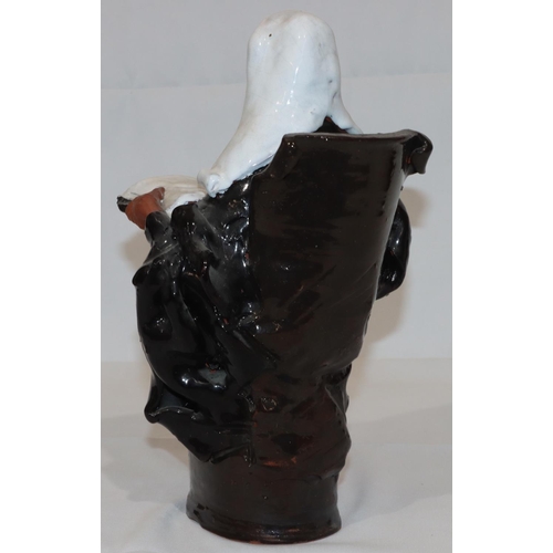 76 - A glazed earthenware figure of a seated judge, 31cm high