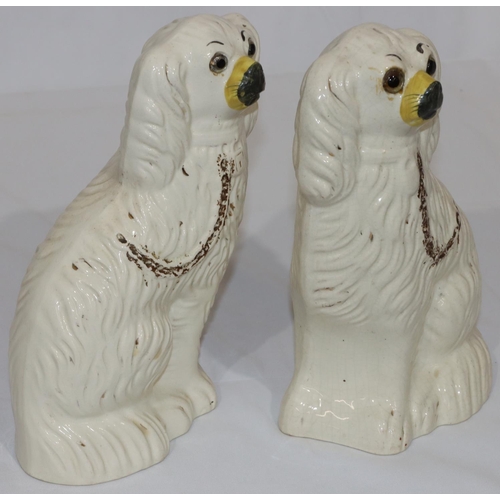 79 - A pair of 19th Century Staffordshire figures of seated spaniels with painted gilt decoration and gla... 