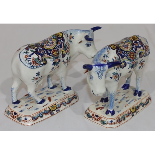 87 - A pair of Continental Delft figures of cattle on white ground with multi-coloured floral, leaf and s... 