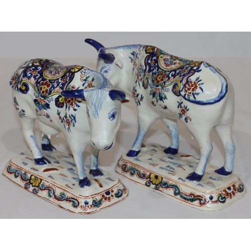 87 - A pair of Continental Delft figures of cattle on white ground with multi-coloured floral, leaf and s... 