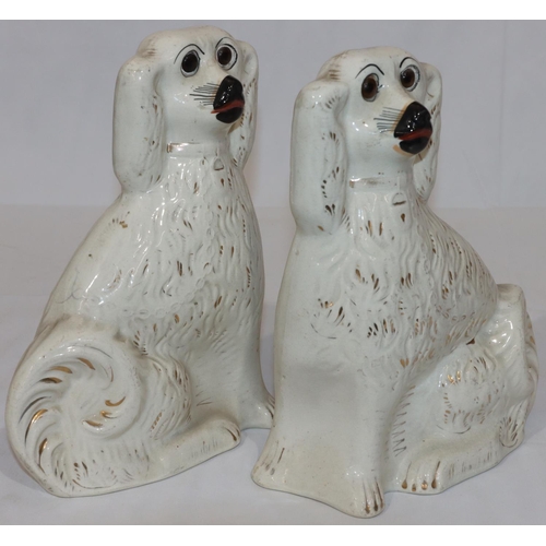 89 - A pair of 19th Century Staffordshire figures of seated spaniels with gilt decoration and glass eyes ... 